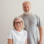 Cheerful senior couple smiling indoors, capturing a warm and happy moment together.